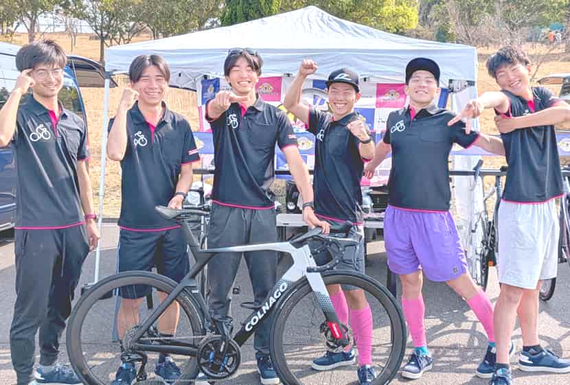eNShareCyclingTeam 集合写真。チームユニフォームを着用し自転車と共に笑顔でポーズ