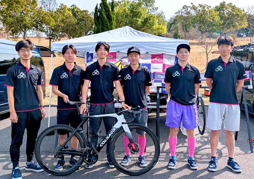 eNShareCyclingTeamの選手たちが腕を上げて笑顔で集合撮影しているオフショット